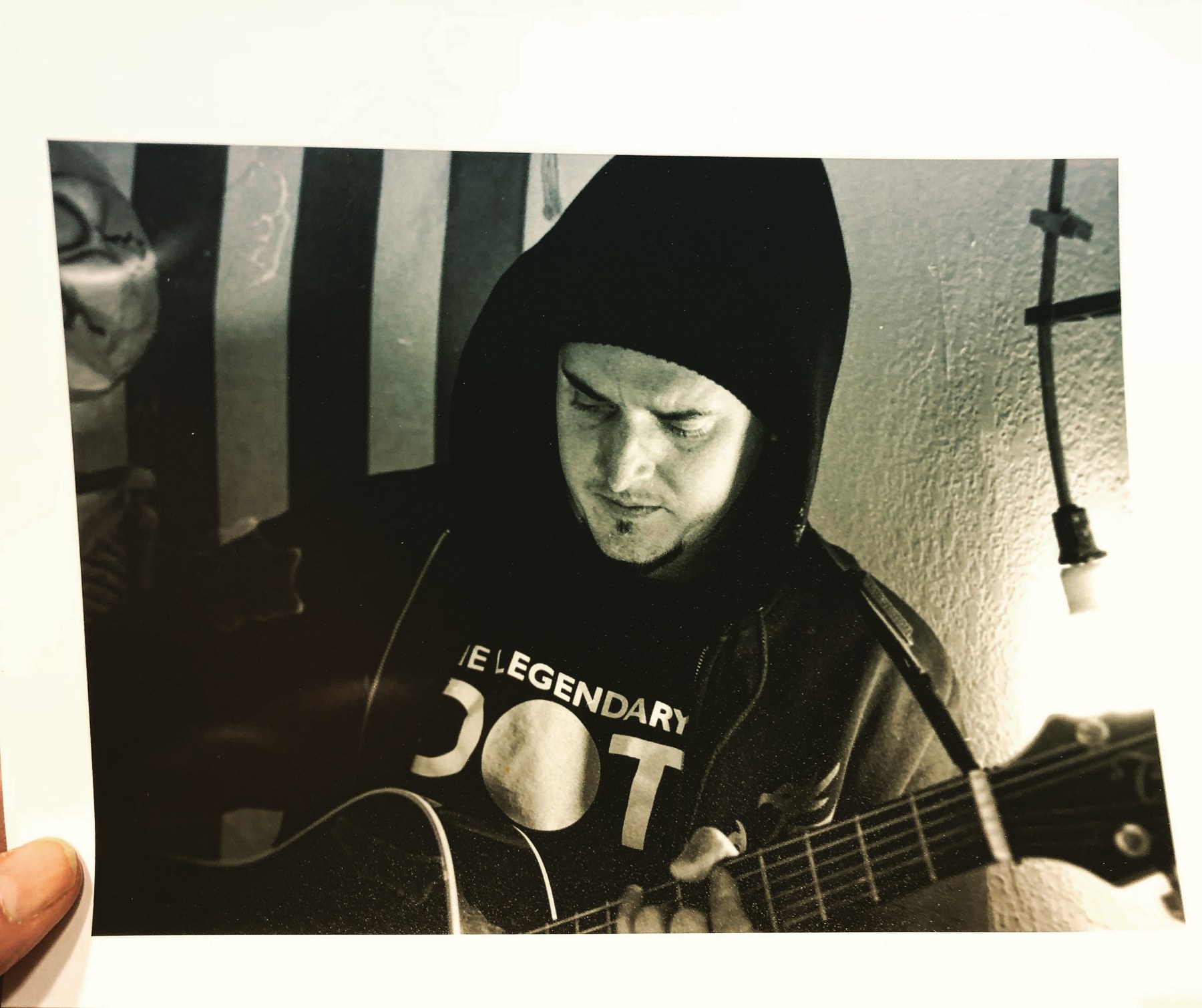Doug playing an acoustic guitar in an archival black-and-white photograph